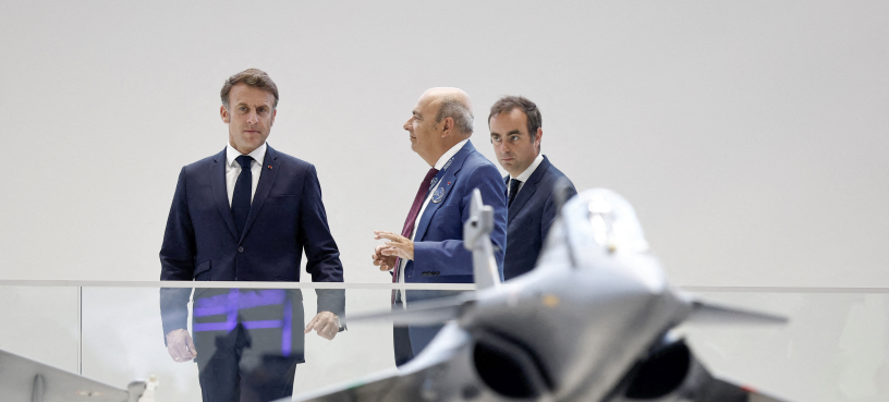 Le président français Emmanuel Macron (à gauche), accompagné du ministre français des Armées Sébastien Lecornu (à droite), écoute Eric Trappier, président-directeur général de Dassault Aviation, lors d'une visite à la 55e édition du Salon international de l'aéronautique et de l'espace (SIAE) au Bourget, le 20 juin 2025 (Photo by Benoit Tessier / POOL / AFP)
