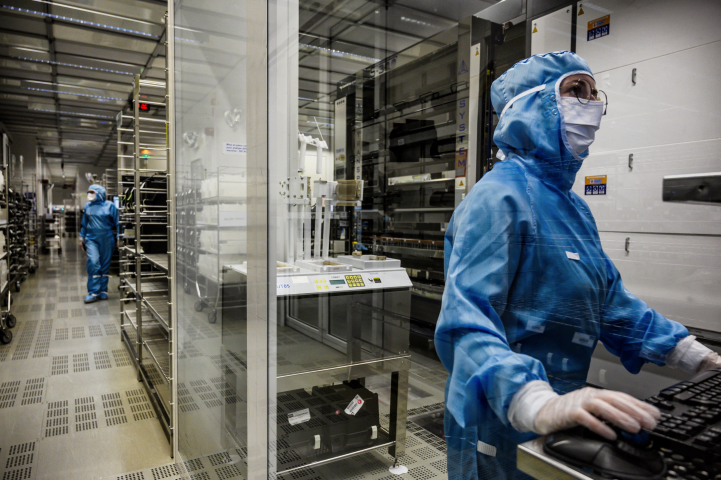 Des employés de Soitec dans les salles blanches de l'usine de Bernin, près de Grenoble (Photo by JEFF PACHOUD / AFP)